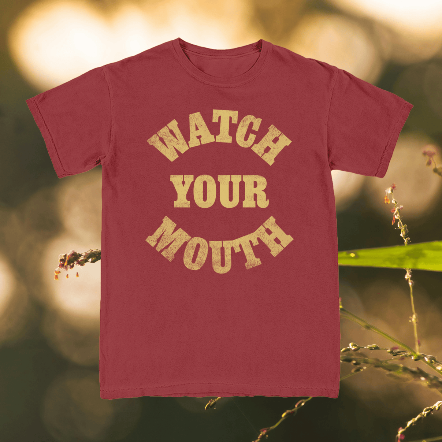 Maroon t-shirt with 'Watch Your Mouth' text on a natural background
