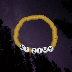 Yellow bracelet with 'MTZION' beads against a dark sky background